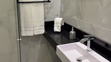 Apartamento standard | Banheiro | Chuveiro, produtos de toalete grátis, secador de cabelo