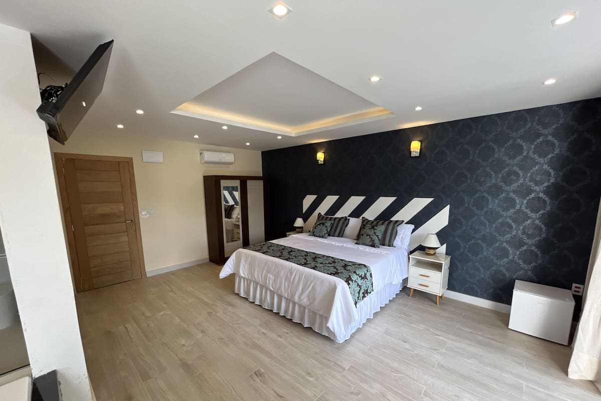 A bedroom with a bed, bedside tables, a wardrobe, and a ceiling light fixture.