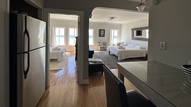 A spacious room with a bed, a desk, and a view of the beach. - The Vurpillat Beachfront Hotel (Hermosa Beach)