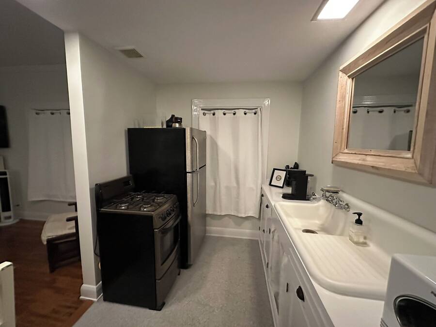 A compact kitchen with a stove, refrigerator, and sink.
