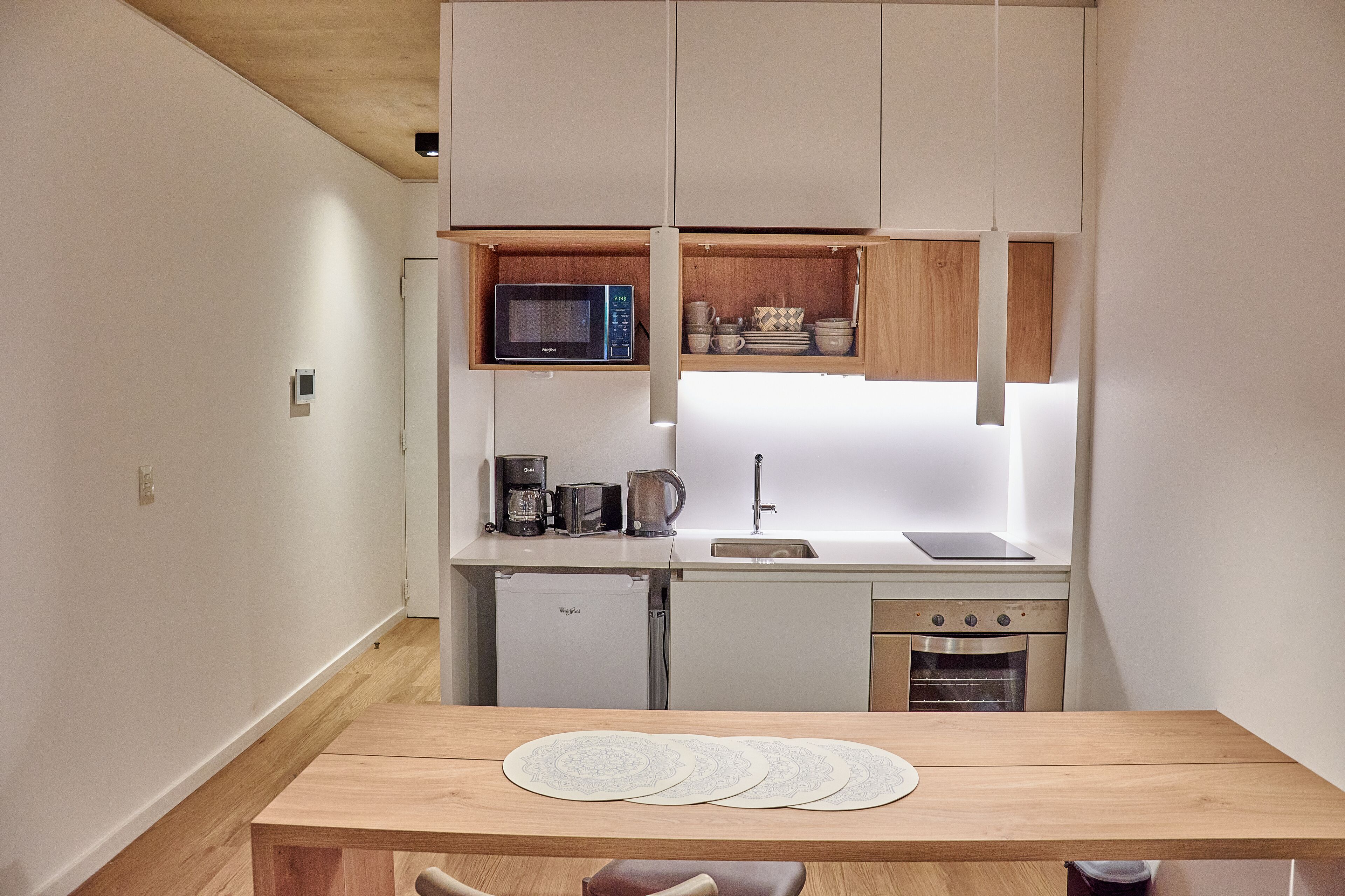 Cocina compacta con microondas, cafetera y horno.