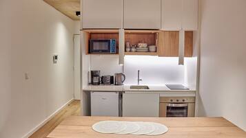 Cocina compacta con microondas, cafetera y horno.
