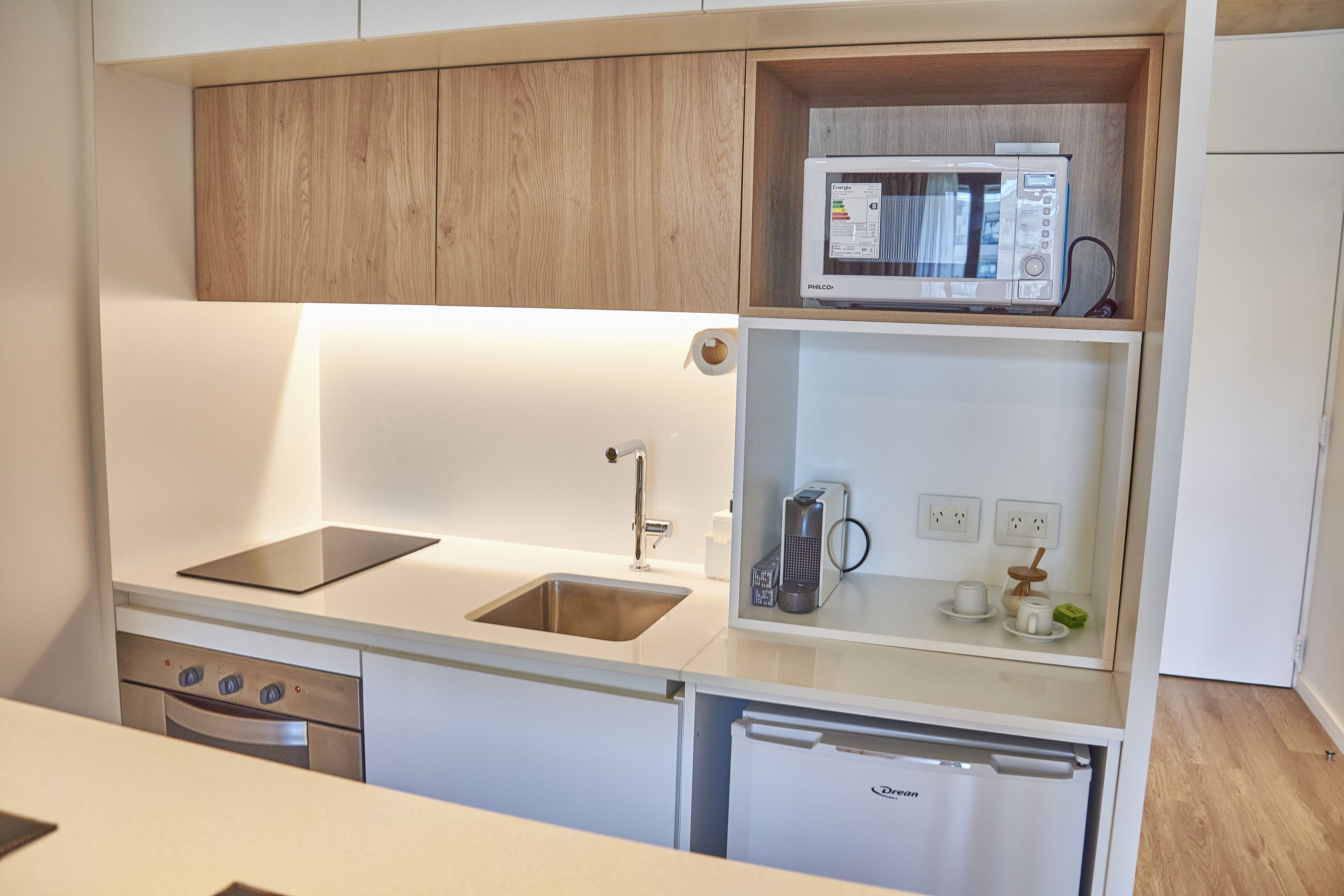 A compact kitchen with a built-in microwave, a sink, and a dishwasher.