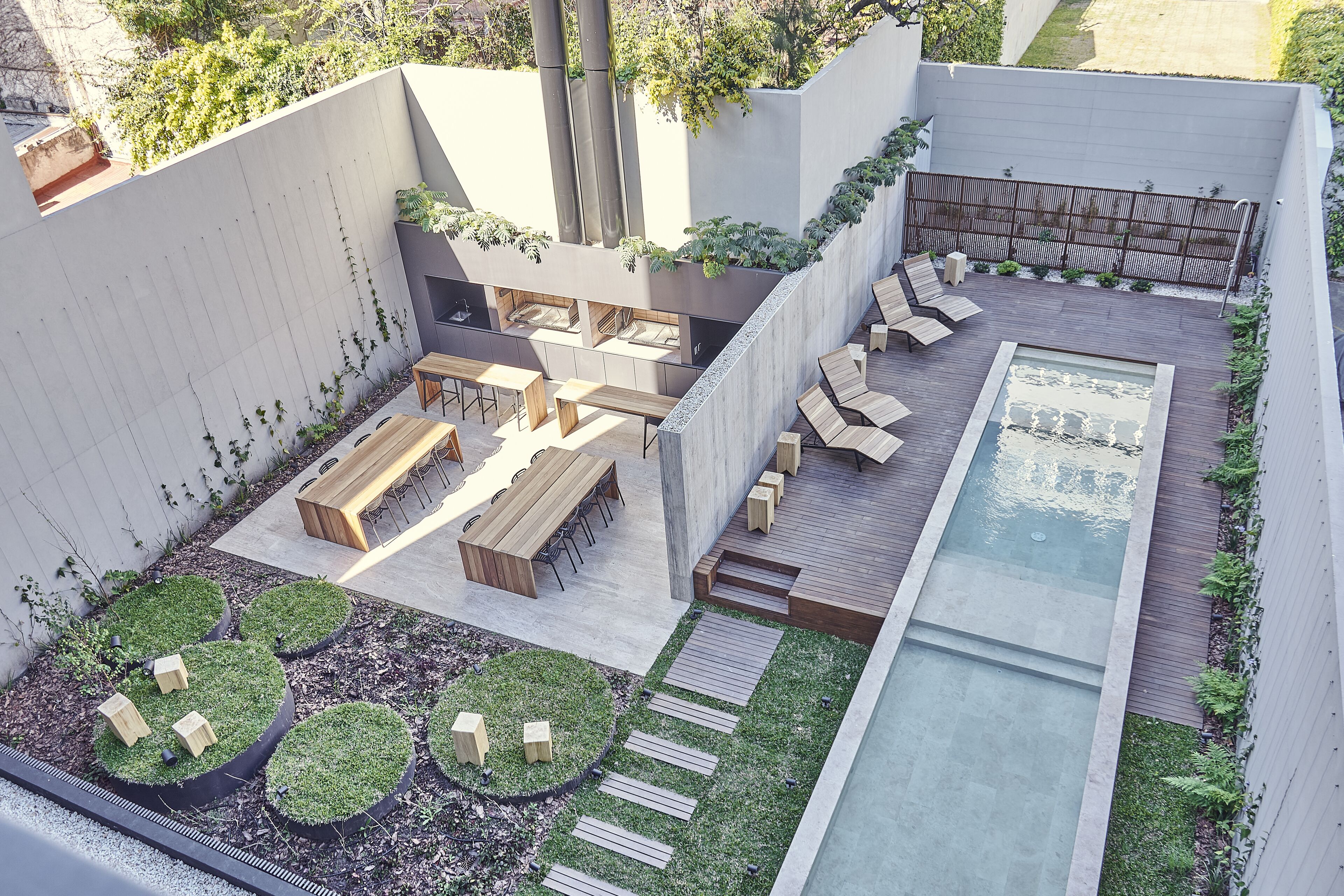 A rooftop garden with a pool, seating areas, and a pergola.