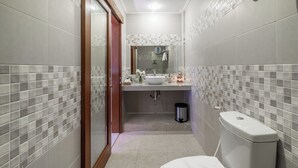 A bathroom with a toilet, sink, and shower area. - Puri Uma Ratu (Keroboken Kelod)