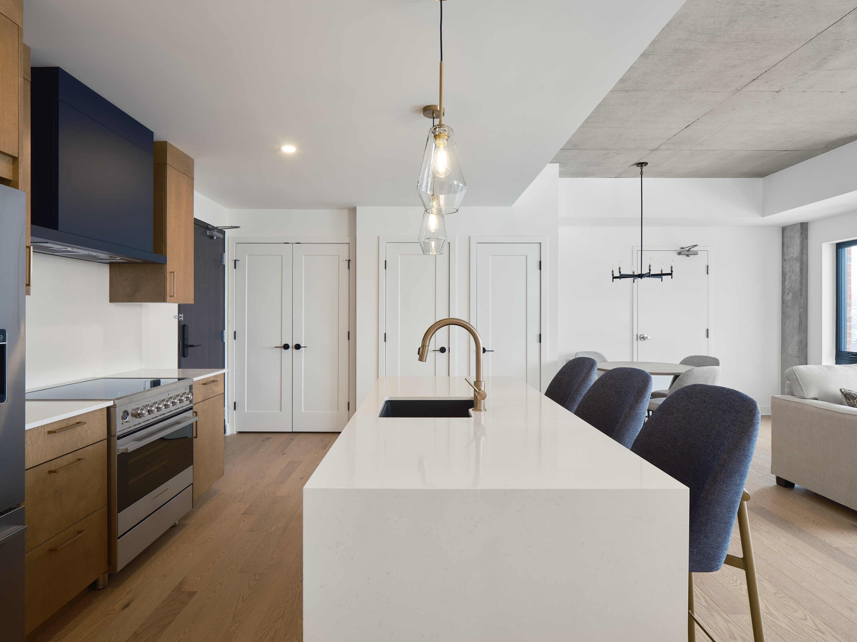 Una cocina moderna con una isla central, armarios de madera y electrodomésticos de acero inoxidable.