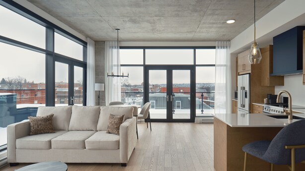 A modern apartment with a large living area, a kitchen, and a dining space. - Quartier des Marinas - Hôtel Expérience (Magog)