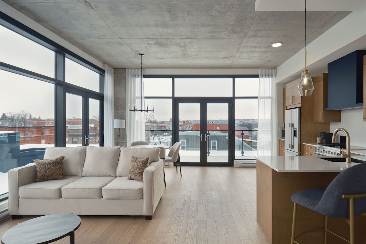 A modern apartment with a large living area, a kitchen, and a dining space.