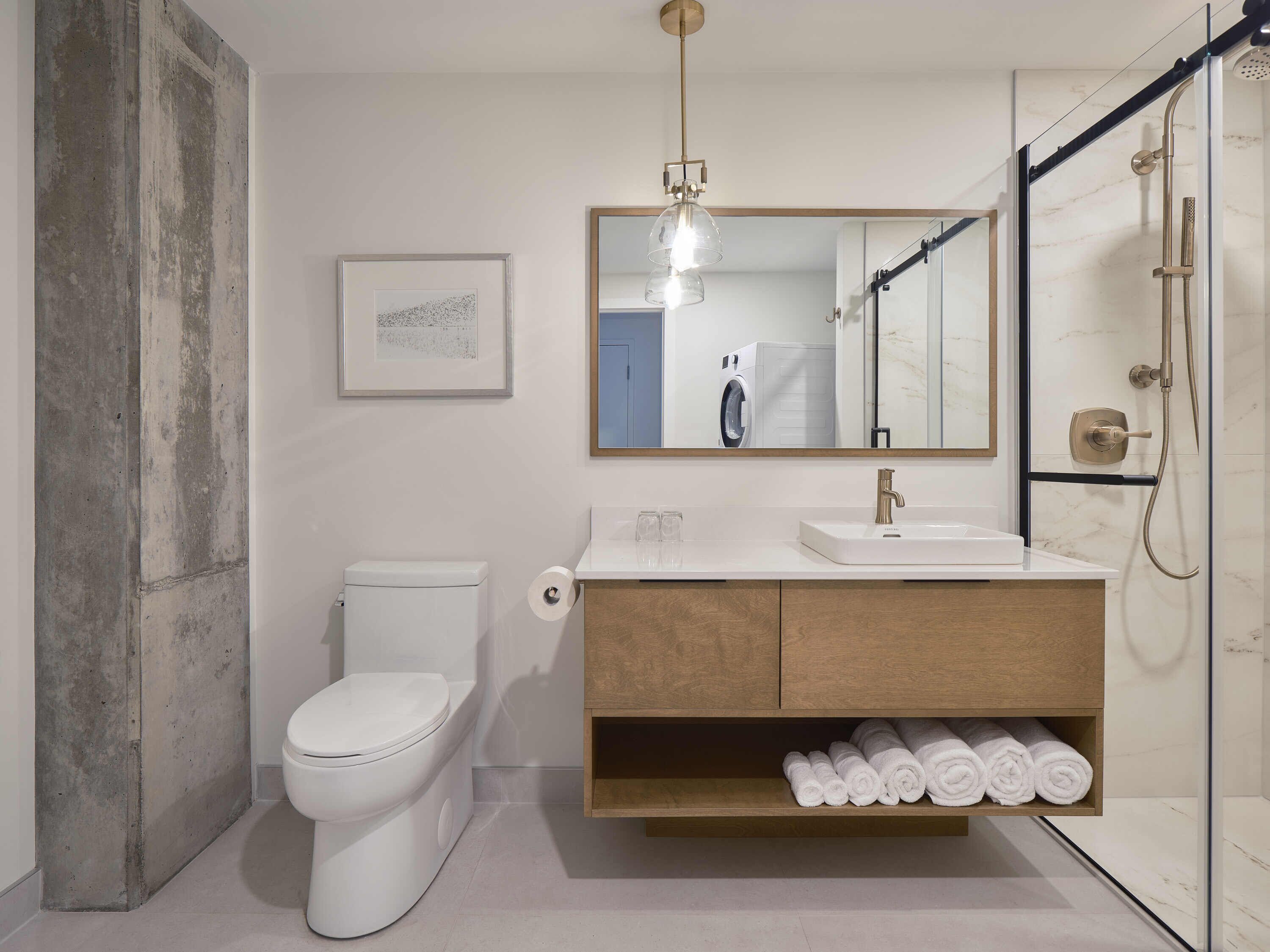 Une salle de bain moderne équipée de toilettes, d’un lavabo et d’une douche.