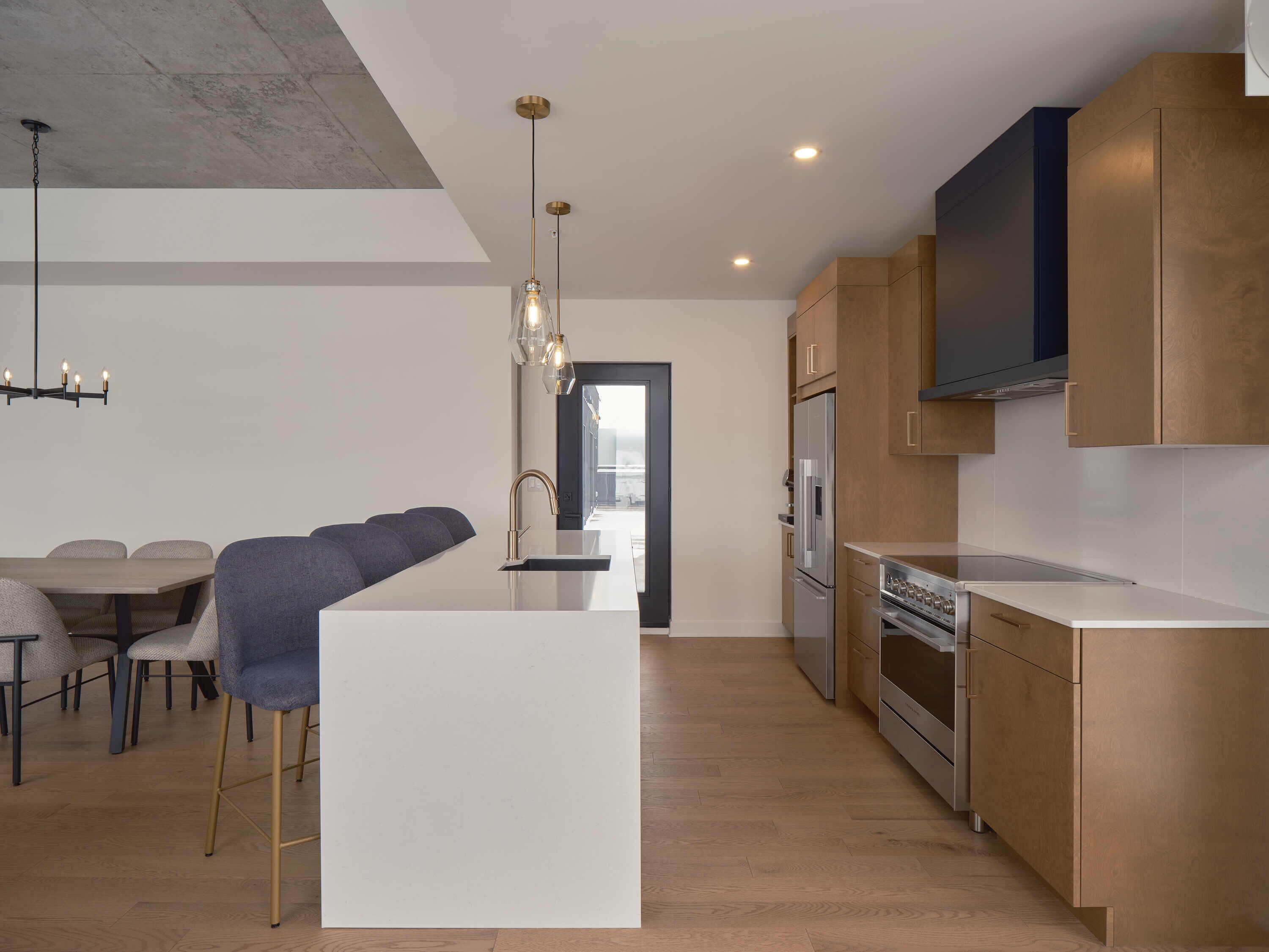 A modern kitchen with wooden cabinets, stainless steel appliances, and a central island.