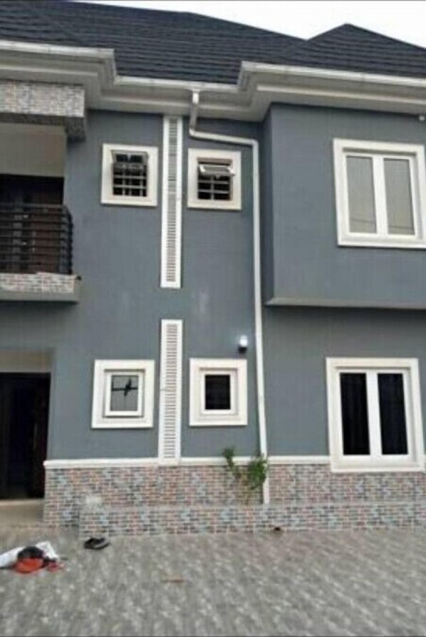 Stylish two-story building with a central vertical element and a tiled entrance area.