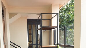 Ein Korridor mit Fliesenboden, einer Treppe und einem Blumentopf.