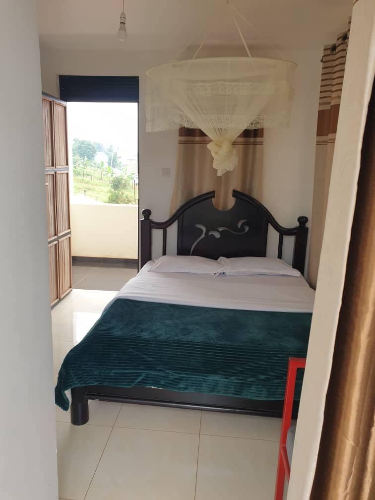 Un dormitorio con una cama, una ventana y cortinas.