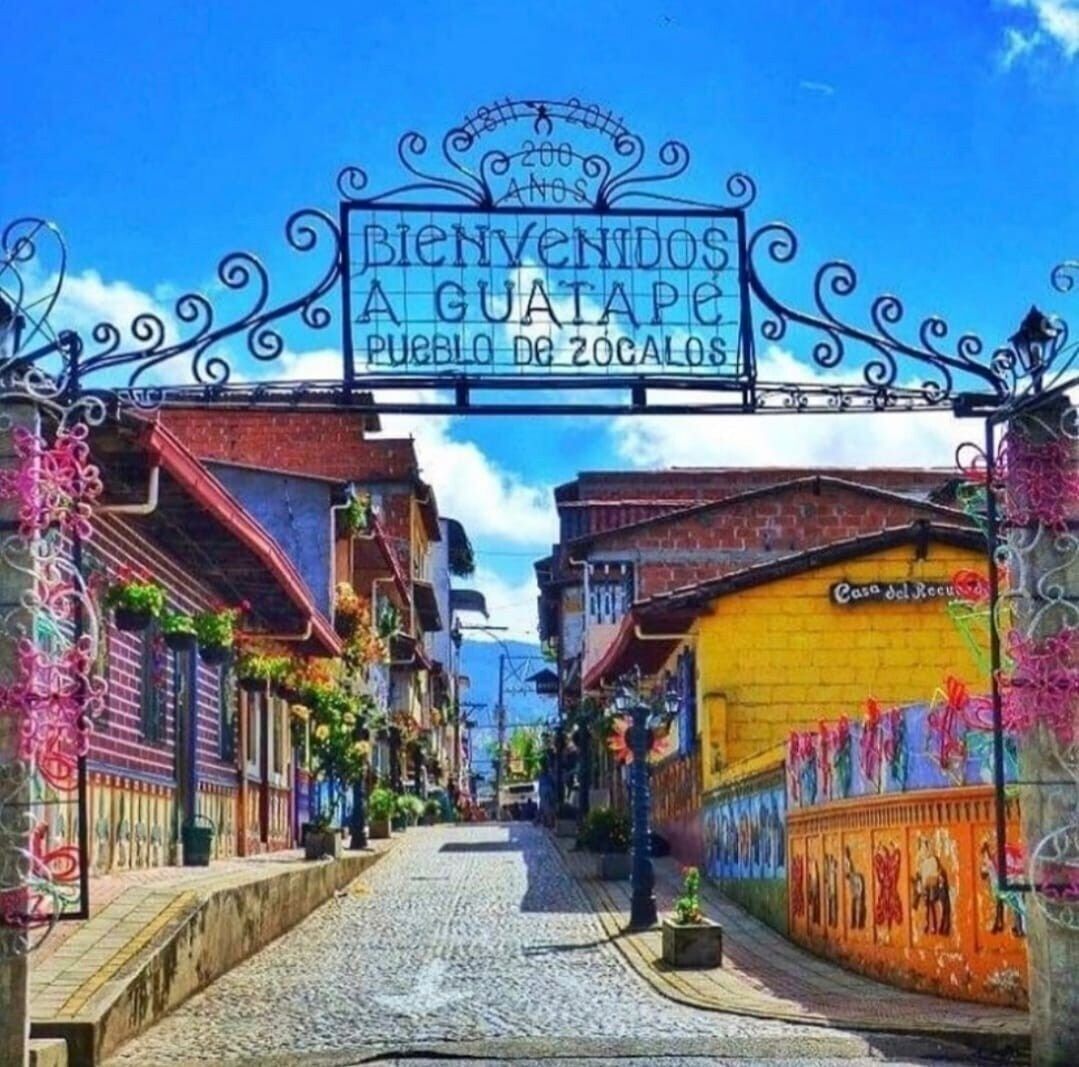 A street entrance with a sign reading "Bienvenidos a Guatemala Pueblo de Zocalos".