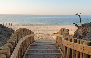 A wooden staircase leading to a beach with a clear view of the ocean. - Cozy home in Wiselka with WiFi (Wiselka)