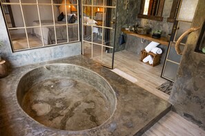 A rustic bathroom with a large bathtub, wooden shelves, and a mirror. - Hotel Serra Bonita (Delfim Moreira)