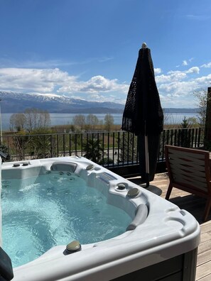 A hot tub on a deck with a view of mountains and a lake. - Toka Hotel Restaurant (Udënisht)