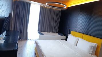A hotel room with a bed, a desk, and a television.