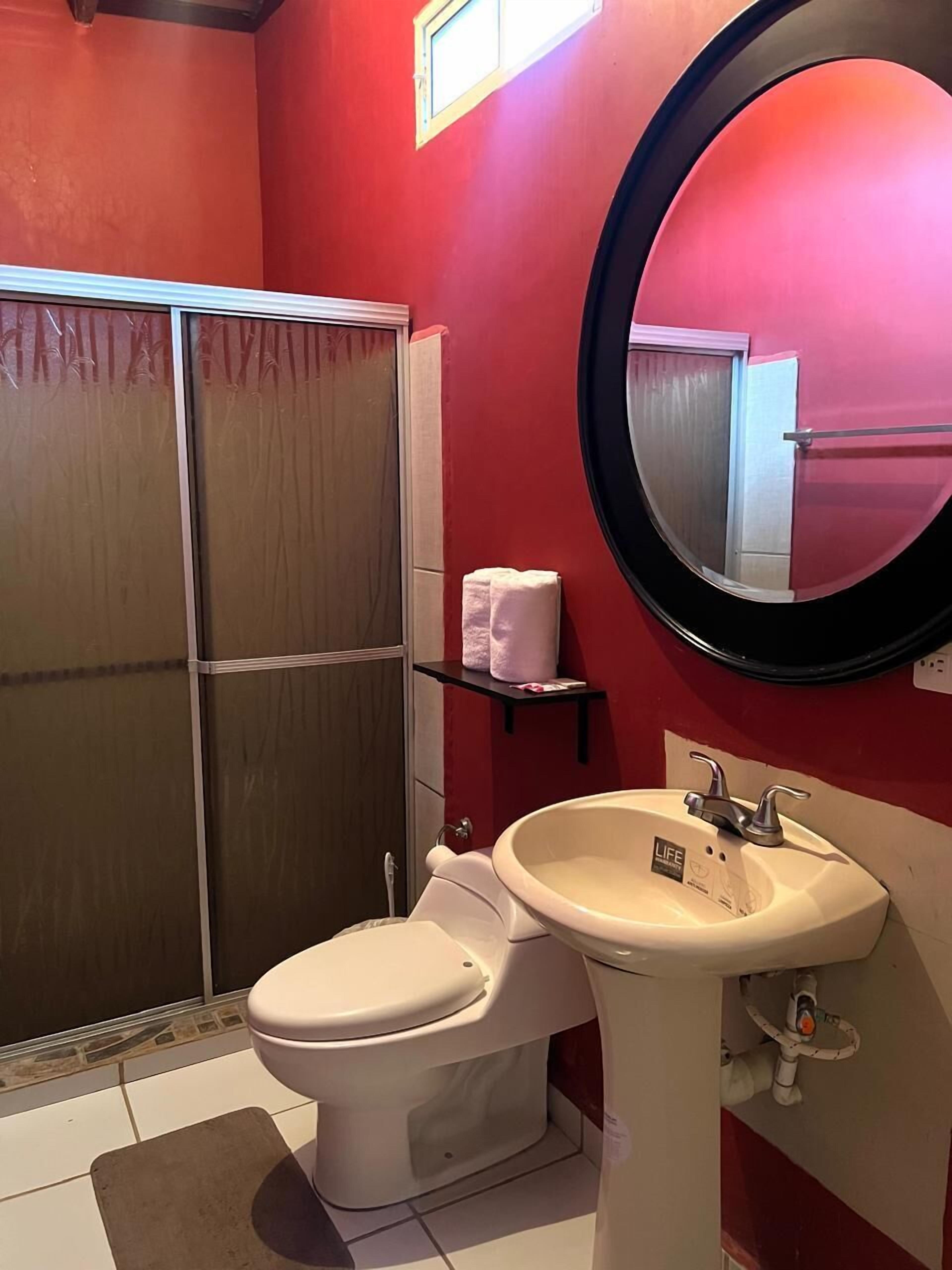 A bathroom with a toilet, sink, and shower.