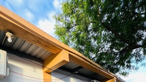 A row of single-story buildings with wooden garage doors and air conditioning units. - APARTA HOTEL PALMEROLA (Comayagua)
