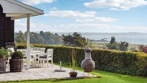 Un patio con mobiliario exterior, una planta en maceta y una urna decorativa.