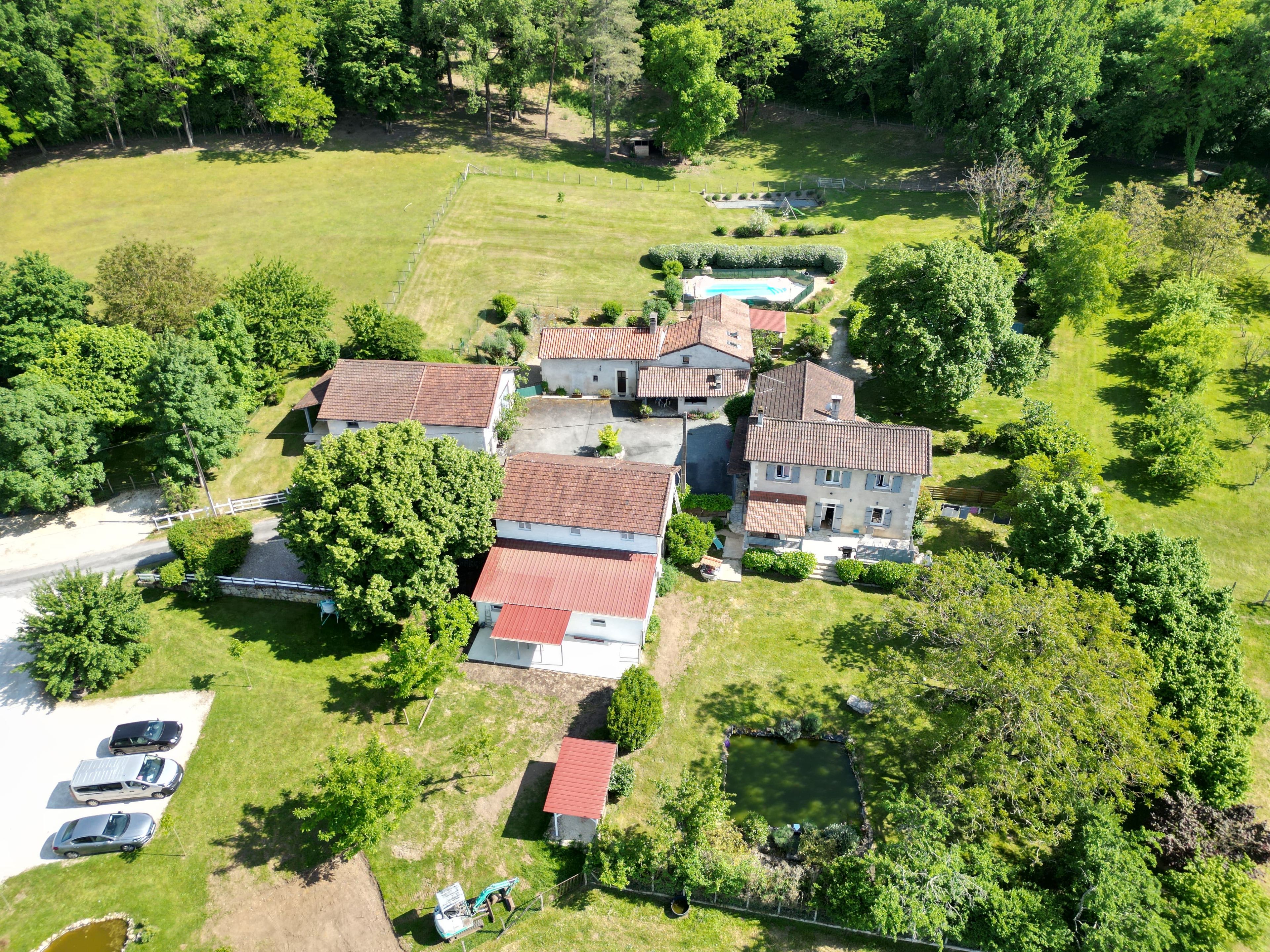 Vista aérea de una zona residencial con varias casas, una piscina y un patio cercado.