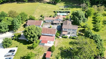 Vista aérea de una zona residencial con varias casas, una piscina y un patio cercado.