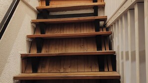 A wooden staircase with a handrail, leading to a landing with a light fixture. - Les Gîtes de Petrocoriis (Boulazac-Isle-Manoire)