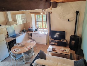 A compact kitchen with a dining area, a sofa, and a television. - Les Gîtes de Petrocoriis (Boulazac-Isle-Manoire)