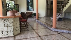 A spacious lobby with a stone counter, seating area, and a staircase.