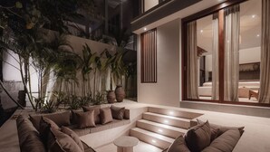 Ein modernes Wohnzimmer mit einer gebogenen Couch, einem runden Couchtisch und einer Treppe zu einer oberen Ebene.