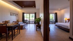 A hotel room with a dining area, a bed, a sofa, and a large window. - RB Resort (Pattaya)