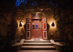 A traditional wooden entrance with a set of stairs leading up to it, surrounded by foliage. - Kumbukgaha Villa (Sigiriya)