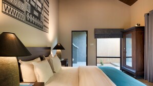 A hotel room with a large bed, two bedside tables with lamps, a wooden cabinet, and a view of the outside. - Kumbukgaha Villa (Sigiriya)