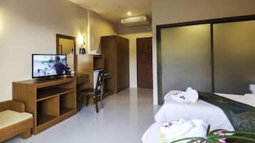 Quarto de hotel com cama, televisão, escrivaninha e cadeira.