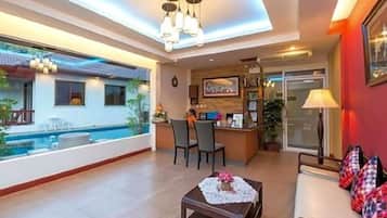Ampla sala de estar com piscina, área de refeições e cozinha.