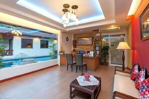 A spacious living area with a pool, a dining area, and a kitchen.