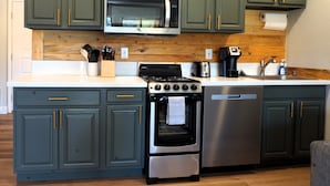 A kitchen with green cabinets, a stainless steel microwave, a stove, and a dishwasher. - GREAT Value! Classy Comfortable King Bed Studio, Sleeps 4! (Granby)