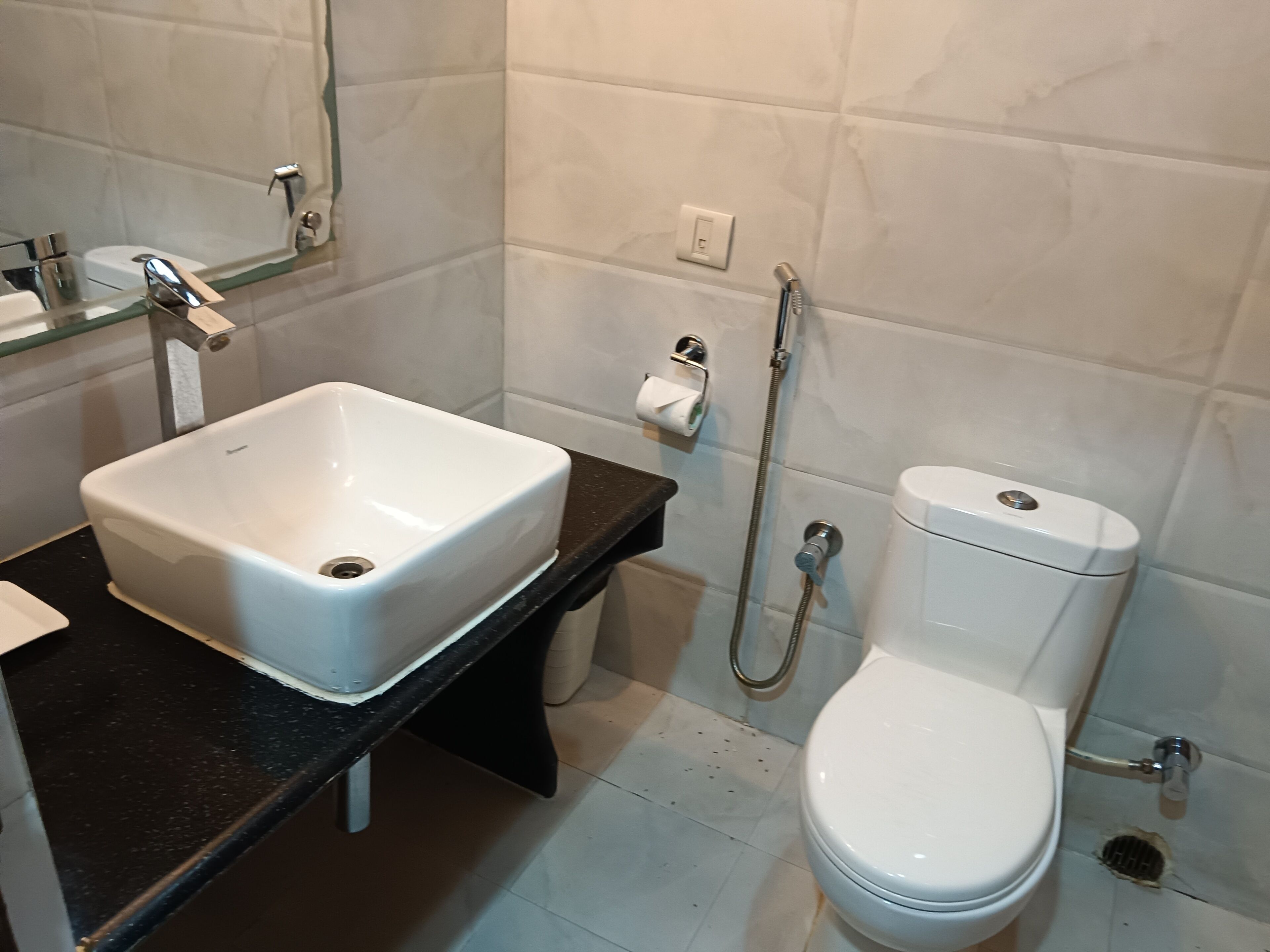 A bathroom with a white sink, toilet, and shower.