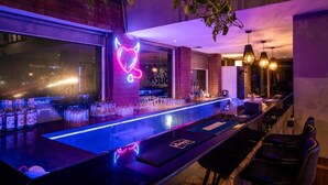 A bar area with a neon heart sign, a long counter, and hanging lights. - The Presidency Hotel In Bhubaneswar (Bhubaneshwar)