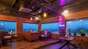 A cozy lounge area with leather sofas, a wooden table, and potted plants. - The Presidency Hotel In Bhubaneswar (Bhubaneshwar)