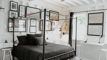 Une chambre à coucher moderne avec un lit à baldaquin, un bureau avec une chaise et une fenêtre donnant sur la ville.
