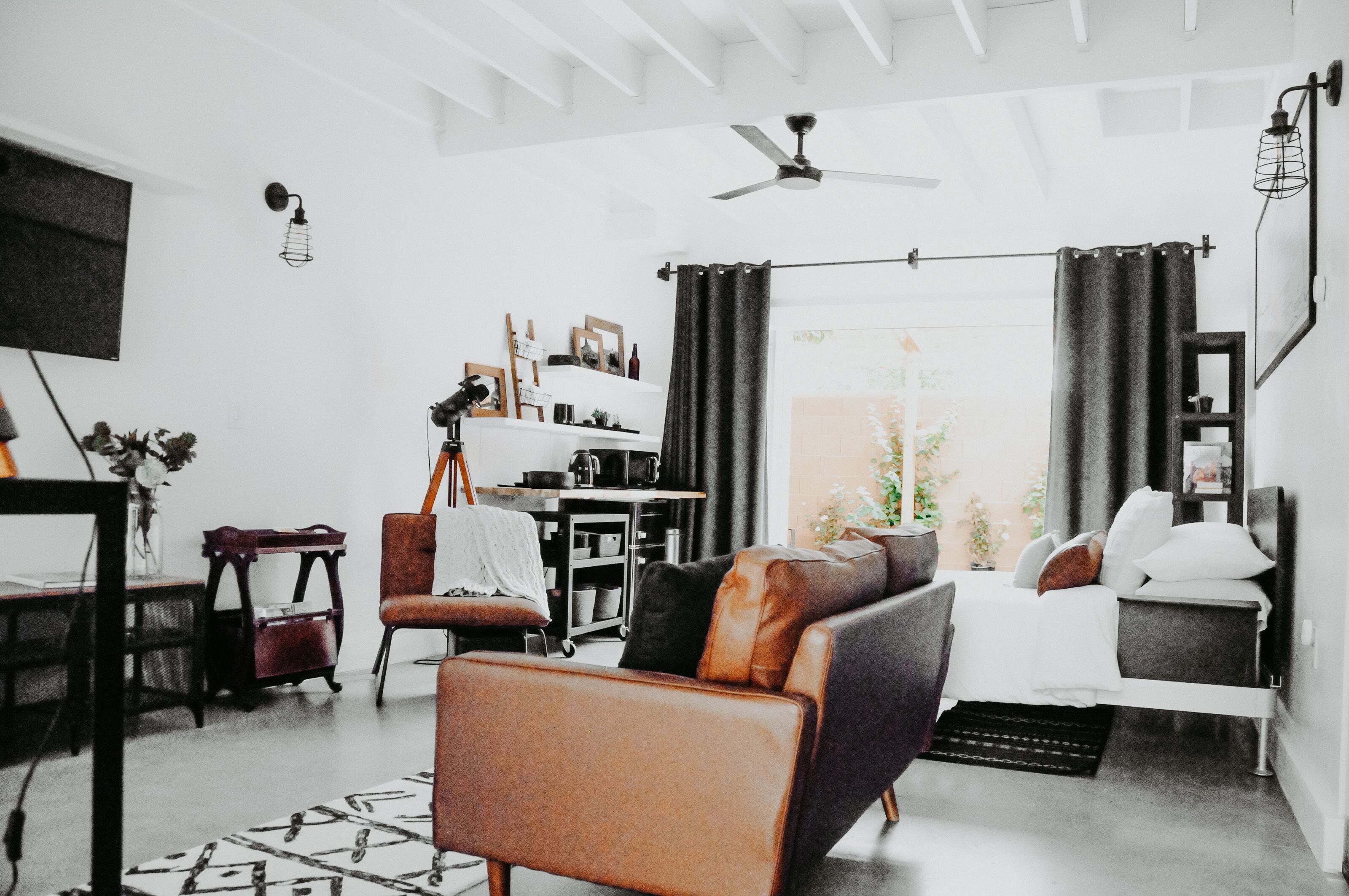 Un salon moderne comprenant un canapé, un fauteuil et un coin repas avec une table et des chaises.