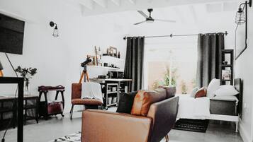 Un salon moderne comprenant un canapé, un fauteuil et un coin repas avec une table et des chaises.