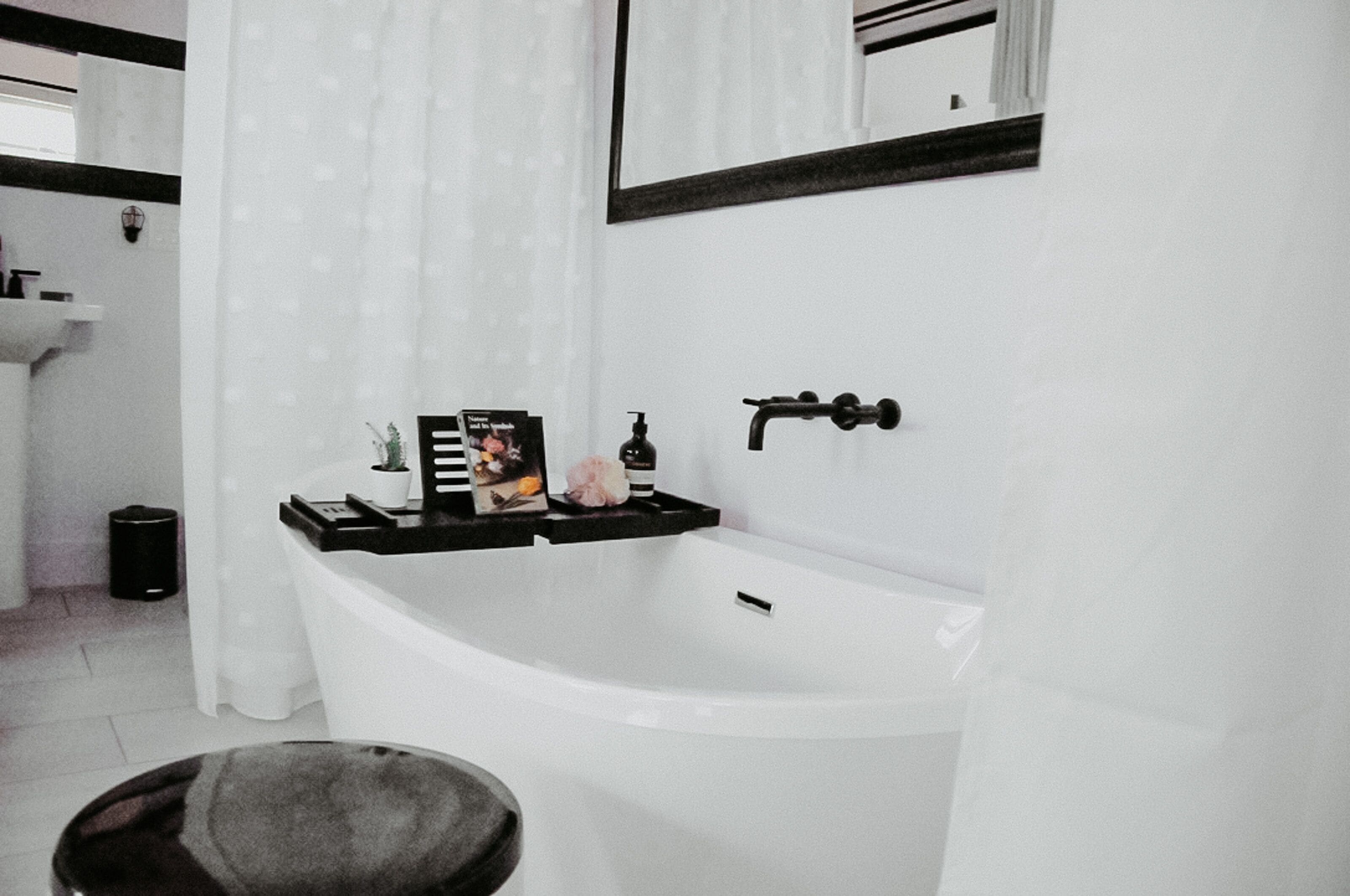 Un baño moderno con una bañera independiente, un lavabo y un espejo.