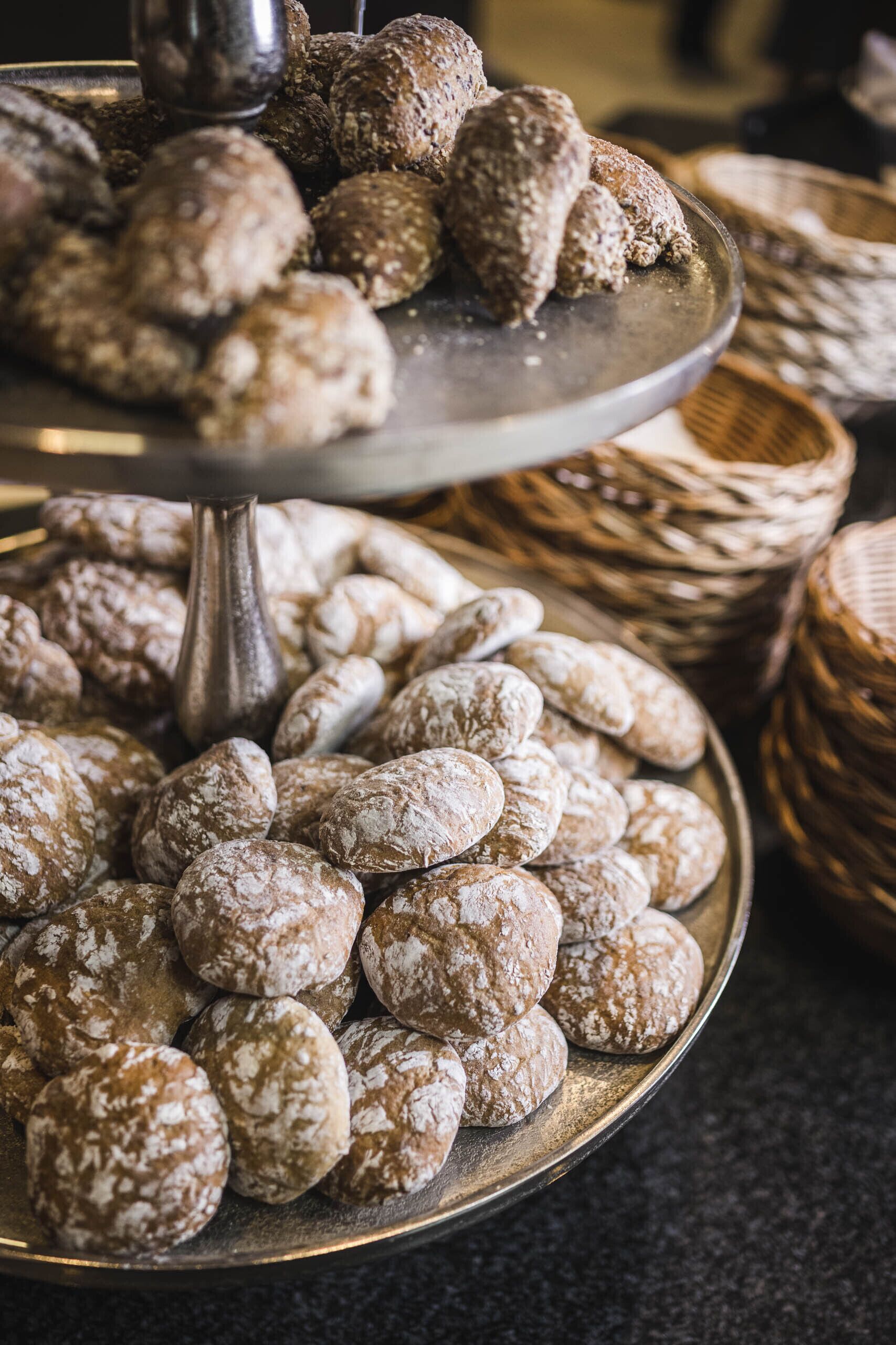 A tray of assorted pastries, including bread and cookies, on a metal stand.