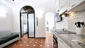 Une cuisine moderne avec des meubles blancs, un plan de travail noir et un pare-feu en carreaux.