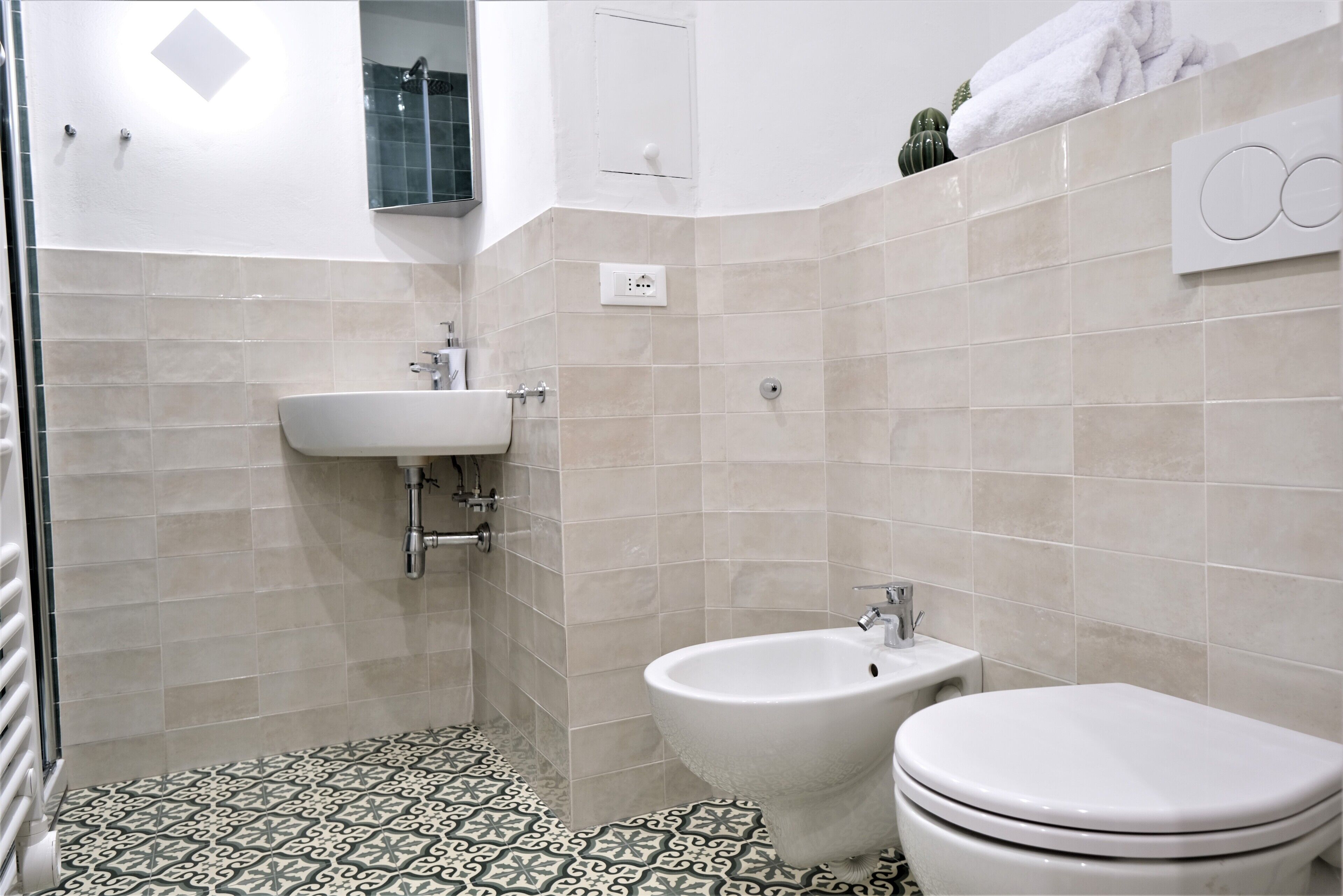 A bathroom with a sink, bidet, and toilet.