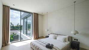 A modern bedroom with a large bed, a view through floor-to-ceiling windows, and a minimalist design. - Villa Yuna (Canggu)