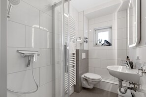 Deluxe appartement | Badkamer | Een haardroger, handdoeken, zeep, shampoo